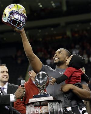 Louisiana-Lafayette quarterback Terrance Broadway holds his son Terrance and the New Orleans Bowl helmet after defeating East Carolina in the New Orleans Bowl today.