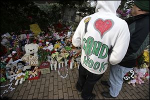 A Sandy Hook resident wears a hand-decorated sweatshirt in support of his town while visiting a memorial to the shooting victims. Visitors from around the world have arrived to offer their sympathy. 