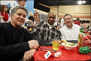 Bernard Clark, center, a Cherry Street Mission resident, joins Greg Scerba, left, and Frank Borgelt, both of CedarCreek Church, at the holiday meal in Perrysburg Township.