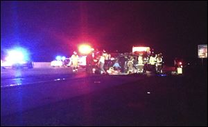 Officials work the scene of a head-on collision involving two minivans on Interstate 75 on Sunday near Franklin, Ohio. The collision killed four people, including a 7-year-old boy, from two different families in Ohio and Tennessee just two days before Christmas. Two other children were critically injured in the collision.