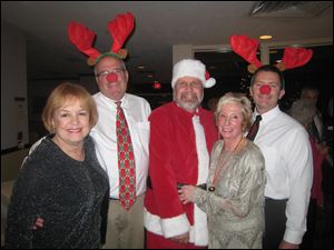 Toledo Ski Club Christmas Party co-chairman Karen Wolfe, 'reindeer' Peter Mainhardt, 'Santa' Jim Wallace, co-chariman Ginger Safford, and 'reindeer' Ed Brown revel in the holiday spirit.