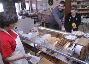 Barb Johnson fills a doughnut order for customers Nick Wiczynski and Sarah Stephens at Wixey Bakery.