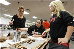 Kim Murry, left, co-coordinator of the high school program, and high school students Sarah Keith, center, and Valerie Nofziger make buckeyes for a caroling event and party.