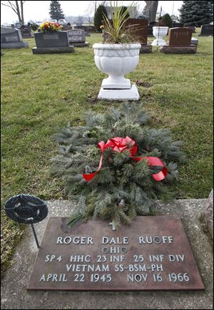 An evergreen blanket made by Wauseon High School students covers  the grave of Roger Dale Ruoff at Wauseon Union Cemetery.