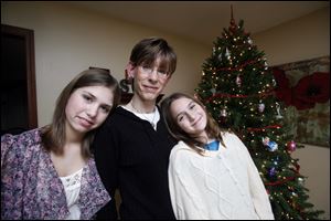 Sonja Delaney, center, and her daughters, Olivia Hann, left, 14, and Amelia Hann, 10, pose for a portrait next to their Christmas tree in Waterville.  Through Project Bethlehem they have been able to purchase Christmas gifts for two needy families.