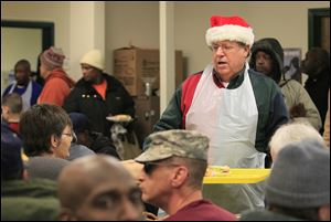 Chuck Hodge delivers a tray of dinners to hungry diners at St. Paul's Community Center on Christmas Eve.