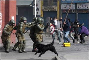 A dog runs as police clash with student protesters in Santiago, Chile, in July.
