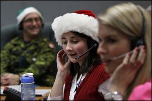 Volunteers take phone calls from children asking where Santa is and when he will deliver presents to their house, during the annual NORAD Tracks Santa Operation at the North American Aerospace Defense Command, or NORAD, at Peterson Air Force Base, in Colorado Springs, Colo., 
