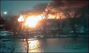 This image taken from video provided by WHAM13-TV, shows a wide view of homes on fire in an area where a gunman ambushed four volunteer firefighters responding to an intense pre-dawn house fire early today in Webster, N.Y.