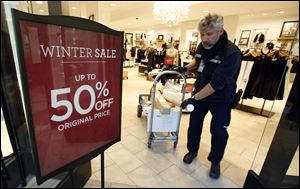 FedEx courier Andrew Standeven makes last minute deliveries to businesses at the CambridgeSide Galleria mall in Cambridge, Mass., Monday, Dec. 24, 2012.