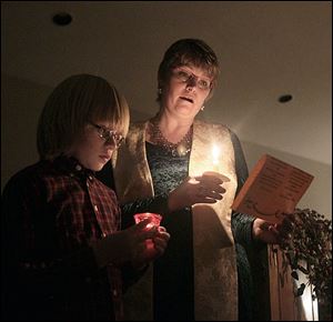 The Rev. Lynn Kerr, right, and her son, Rowan, 11, left, sing Silent Night.'