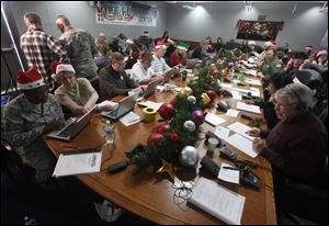 Volunteers take phone calls from children asking where Santa is and when he will deliver presents to their house, during the annual NORAD Tracks Santa Operation, at the North American Aerospace Defense Command, or NORAD, at Peterson Air Force Base, in Colorado Springs, Colo.