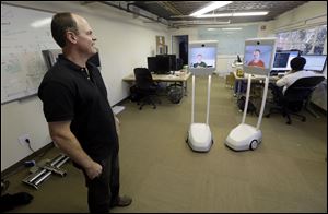Bo Preising, Suitable Technologies’ vice president of engineering, addresses screen images of Josh Faust and Josh Tyler through a Beam remote presence system in Palo Alto, Calif. The device lets employees working from home stay connected with colleagues at the office.