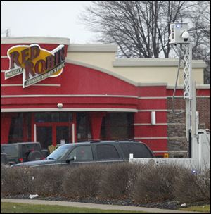 A portable police camera keeps watch in the parking lot of a restaurant on Monroe Street in Toledo.