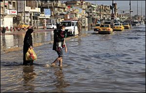 An Iraqi family make their way through flood water, after heavy rain fell in Baghdad, Iraq.