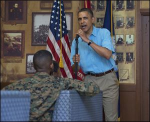 President Obama speaks as he and first lady Michelle Obama, not seen, arrive to visit with members of the military and their families in Anderson Hall at Marine Corp Base Hawaii, Tuesday, in Kaneohe Bay, Hawaii. 