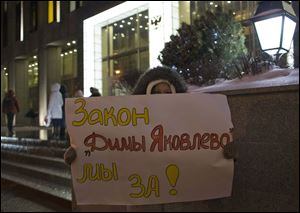 A demonstrator holds a poster reading 