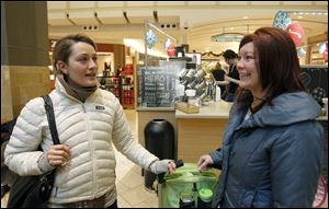Former Toledoan Mandi Dillin of Los Angeles, left, and Sara Matuszewski of Toledo speak about shopping as they wait for coffee at Westfield Franklin Park mall Wednesday.