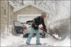 Vickie Stinson shovels her driveway on Alice Street on Wednesday in Port Clinton.