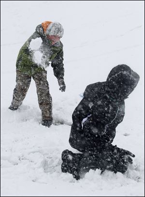 Mason McDougall, 11, of Port Clinton hurls a snowball at brother Ryan McDougall, 13, at a sledding hill in Port Clinton.
