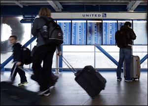 Travelers walk to the ticketing desk at O’Hare International Airport in Chicago. Finding the cheapest fare has become tougher as airlines charge for services such as premium seating and  early boarding. Airlines oppose efforts to make the fee information more accessible.