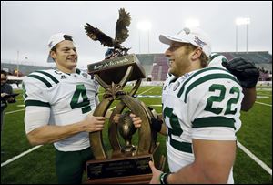 Ohio quarterback Tyler Tettleton (4) and running back Beau Blankenship (22) hoist trophy after their 45-14 win over Louisiana-Monroe in the Independence Bowl NCAA college football game in Shreveport, La.