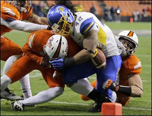 San Jose State running back Ina Liaina loses control of the ball as he is hit by Bowling Green's Cameron Truss, left, and Paul Swan late in the game. The ball rolled out of the end zone but it was ruled that Liaina was down at the 3-yard line.