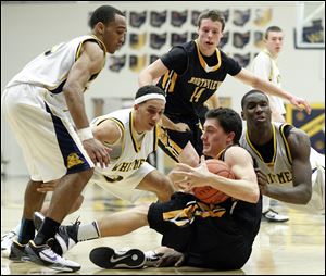 Whitmer's Ricardo Smith (10) Marcus Elliott (32) and  Nigel Hayes (23) battle Sylvania Northview's Chris Nowicki (44), on floor,  for a loose ball. In the background is Northview's Connor Hartnett (14).