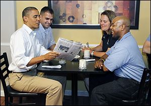 President Obama holds The Blade while sitting in Rick's City Diner in Toledo with Daniel Schlieman, back left, heather Finfrock, and James Fayson.