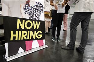 A job seeker confers with a recruiter at a job fair expo in Anaheim, Calif.  In 2012, America's unemployment rate dipped to a four-year-low of 7.7 percent, stock markets rose, builders broke ground on more homes, and November was the best sales month in nearly five years for U.S. automakers.   