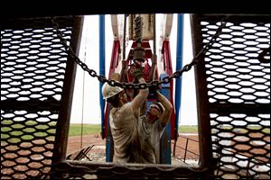 Austin Mitchell, left, and Ryan Lehto work on an oil derrick outside of Williston, N.D. In 2012, domestic crude oil production achieved its biggest one-year gain since 1951, driven by output in North Dakota and Texas. The United States is on pace to pass Saudi Arabia as the world’s top oil producer within two years.