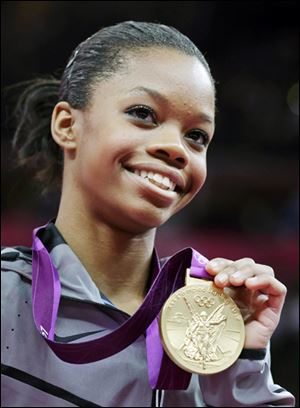 Gabrielle Douglas of the United States displays her gold medal in the artistic gymnastics women's individual all-around competition at the 2012 London Olympics.