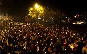 Indians hold candles and march on a street as they mourn the death of a gang rape victim today in New Delhi, India. Indian police charged six men with murder today, adding to accusations that they beat and gang-raped the woman on a New Delhi bus nearly two weeks ago in a case that shocked the country.
