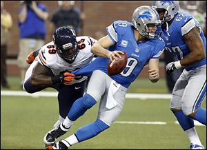 Detroit Lions quarterback Matthew Stafford pulls away from the Bears' Henry Melton, but he wasn't able to escape another loss. He fumbled and threw a costly interception.