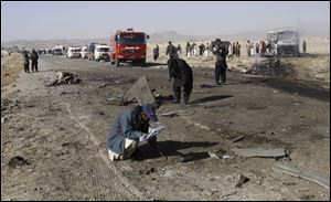 Pakistani police officers, collect evidence from the site of a suicide bombing in Quetta, Pakistan, Sunday.