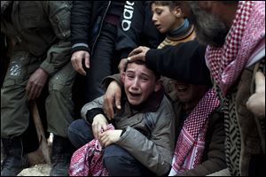 Ahmed, center, mourns his father, Abdulaziz Abu Ahmed Khrer, who was killed by a Syrian army sniper, during his funeral in Idlib in northern Syria.