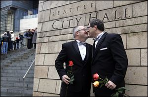Terry Gilbert, left, celebrates with his husband Paul Beppler after their wedding at Seattle City Hall, becoming among the first gay couples to legally wed in the state of Washington.