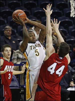 UT's Rian Pearson, who scored 24 points and grabbed 10 rebounds, passes against Illinois-Chicago's Will Simonton in Saturday's game at Savage Arena. The Rockets improved their record to 4-6.