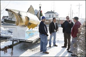 Walleye Madness committee members Mark Matousek, left, Port Clinton Mayor Vince Leone, Don Clemons, and Marty Mortus discuss fine points for the drop of the 600-pound fiber-glass walleye. This year’s ritual will be the 16th.