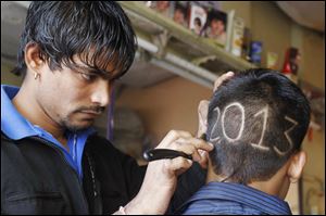 An Indian barber gives finishing touches to the hair style of a young boy with numbers to welcome the New Year 2013 in Ahmadabad, India.