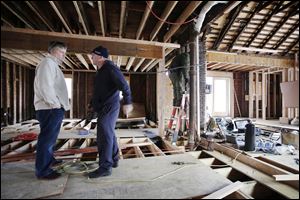 Joseph O'Grady, left, with Rockaway Reach, talks with Kevin Murphy as they discuss the renovation of Murphy's home in the Belle Harbor neighborhood of New York on Dec. 20.