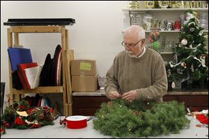 Master designer Keith Brooks works on a wreath for a client at Brooks Florist Saturday during Small Business in downtown Sylvania. Mr. Brooks was arrested on charges that he did not pay sales taxes.