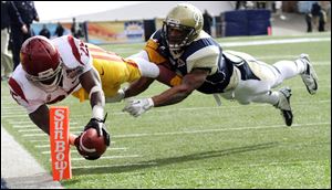 Southern California running back Silas Redd, left, dives into the end zone past Georgia Tech's Louis Young during the Sun Bowl today in El Paso, Texas.
