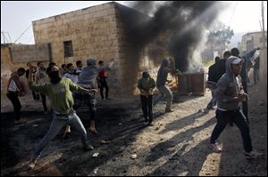 Palestinians hurl stones at Israeli soldiers, not seen, during clashes in the West Bank village of Tamoun, near Jenin.