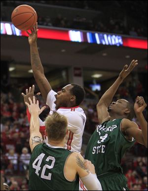 Ohio State's Deshaun Thomas, center, shoots between Chicago State's Matt Ross, left, and Quincy Ukaigwe during the second half of Saturday's game. Ohio State defeated Chicago State 87-44. 