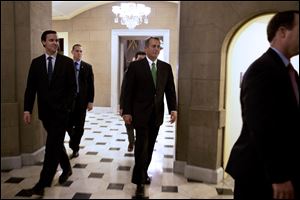 Speaker of the House John Boehner, R-Ohio, center, returns to his office from the House chamber in the evening at the Capitol in Washington as talks continue regarding the 