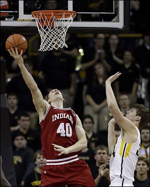 Indiana forward Cody Zeller, left, shoots in front of Iowa center Adam Woodbury. Zeller leads the top scoring offense in the nation.
