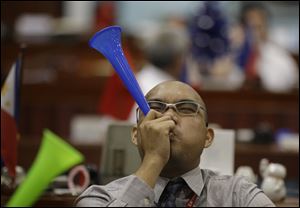 A Filipino trader blows a horn during the first day of trading at Philippine Stock Exchange at the financial district of Makati, south of Manila, Philippines today. 