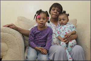 Christine Henderson, Toledo's first homicide victim of 2013, leaves behind her daughters Zyonna Bowen, 3, left, and Zaniayah Bowen, 1. They are with their grandmother Christine Bowen in Ms. Bowen's home in Toledo. 