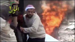 This citizen journalism image taken from video provided by Shaam News Network, shows a wounded man being pulled from the site of a Syrian government airstrike on a gas station in the eastern Damascus suburb of Mleiha, Syria.
